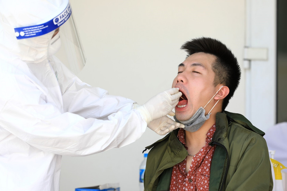 Lấy mẫu dịch hầu họng để xét nghiệm RT-PCR tại Trung tâm Văn hóa Thông tin và Thể thao quận Đống Đa (237 Đặng Tiến Đông) - nơi xét nghiệm cho người dân quận Đống Đa trở về từ Đà Nẵng. (Ảnh: Thành Đạt/TTXVN)