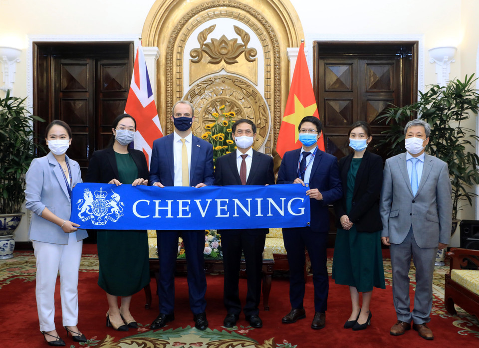 Bộ trưởng Bộ Ngoại giao Bùi Thanh Sơn, Bộ trưởng Ngoại giao và Phát triển Vương quốc Anh Dominic Raab với các công dân nhận học bổng Chevening của Chính phủ Anh. (Ảnh: Lâm Khánh/TTXVN)