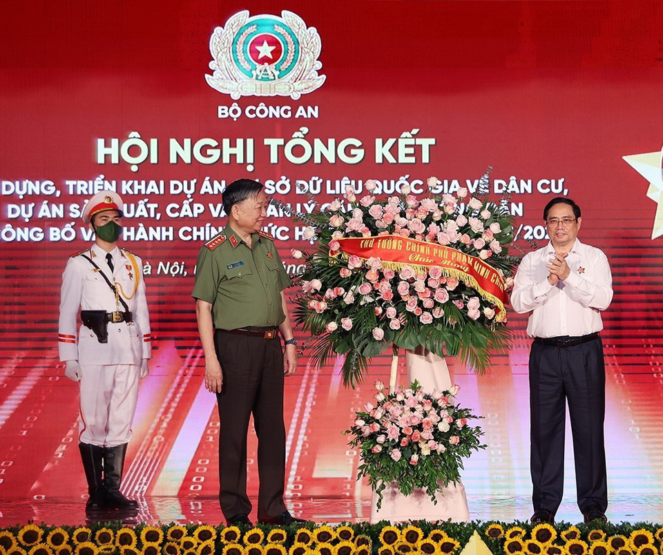 Thủ tướng Chính phủ Phạm Minh Chính tặng hoa chúc mừng Bộ Công an đã hoàn thành Dự án Cơ sở dữ liệu quốc gia về dân cư và Dự án sản xuất, cấp và quản lý căn cước công dân. (Ảnh: Dương Giang/TTXVN)