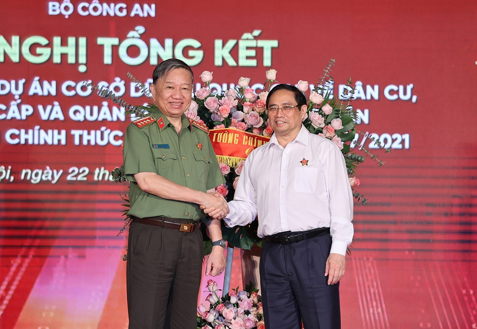 Thủ tướng Chính phủ Phạm Minh Chính tặng hoa chúc mừng Bộ Công an đã hoàn thành Dự án Cơ sở dữ liệu quốc gia về dân cư và Dự án sản xuất, cấp và quản lý căn cước công dân. (Ảnh: Dương Giang/TTXVN)
