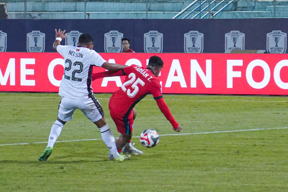 Tình huống va chạm giữa Nelson Viegas (số 22) bên phía Timor Leste với Farhan Zulkifli. Sau khi tham khảo VAR, trọng tài xác định không có phạt đền cho đội khách. (Ảnh: Việt Anh/Vietnam+)