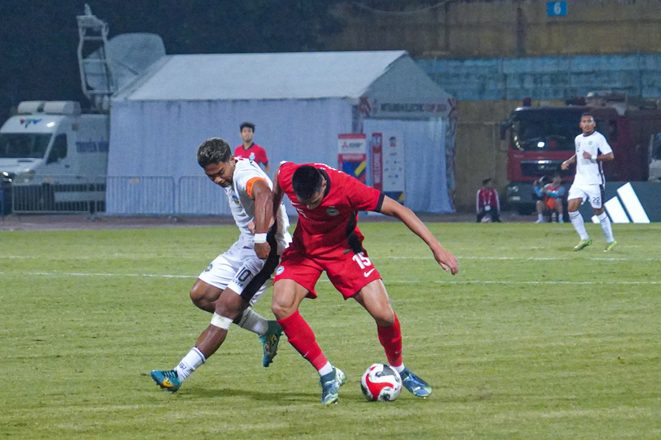 Hiểu rõ sự nguy hiểm của thủ quân bên phía Timor Leste, Singapore cắt cử trung vệ cao to Lionel Tan theo sát Joao Pedro. (Ảnh: Việt Anh/Vietnam+)