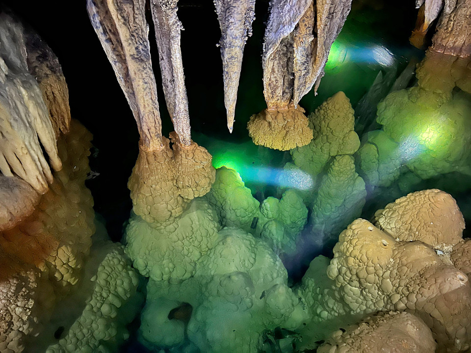 Đủ loại cột đá, măng đá, đủ hình dáng cao thấp ‘mọc’ lên từ dưới lòng nước vươn mình chạm với những cột đá, măng đá rủ xuống từ nóc hang. (Ảnh: Mai Mai/Vietnam+)