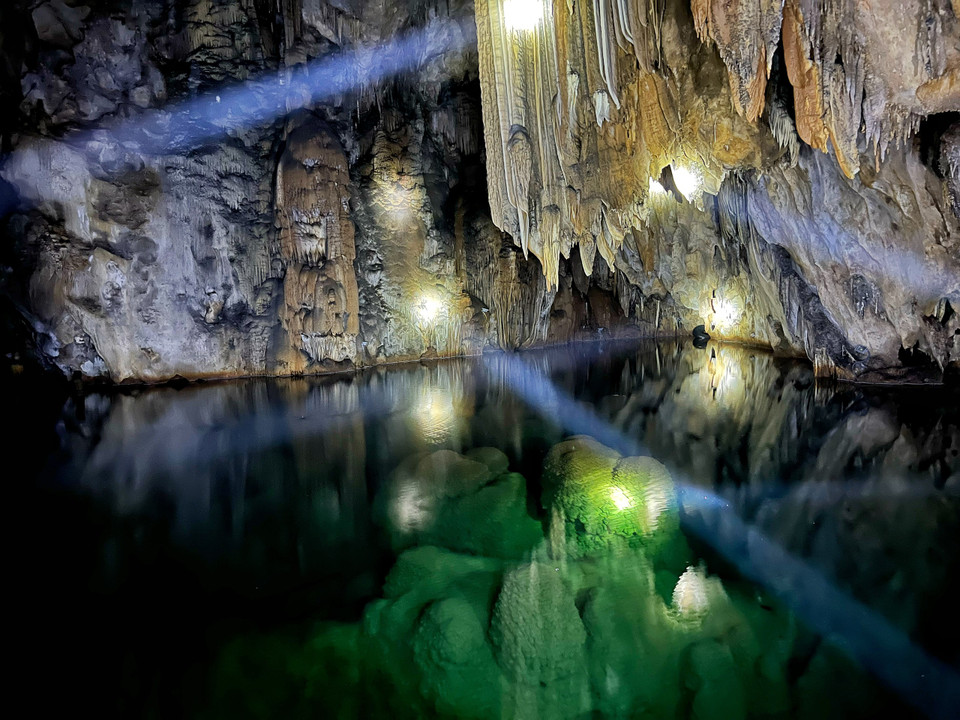 Đáng ngạc nhiên là dù nằm ở độ cao gần 1.000 m so với mực nước biển, trong lòng động lại xuất hiện hồ nước xanh ngăn ngắt, rộng tới gần 1.000 m2, nước ăm ắp trong vắt quanh năm và đây là một bí ẩn của động Nam Sơn. (Ảnh: Mai Mai/Vietnam+)