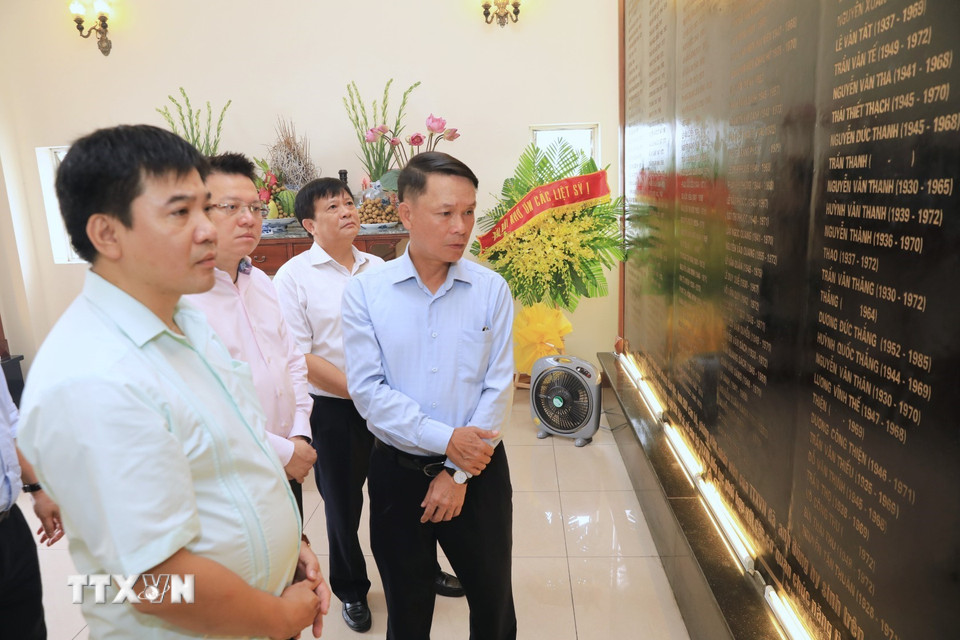 Ông Nguyễn Đức Lợi, Ủy viên Trung ương Đảng, Tổng Giám đốc Thông tấn xã Việt Nam cùng các đại biểu thăm bia ghi danh các liệt sỹ của TTXVN. (Ảnh: Thành Đạt/TTXVN)