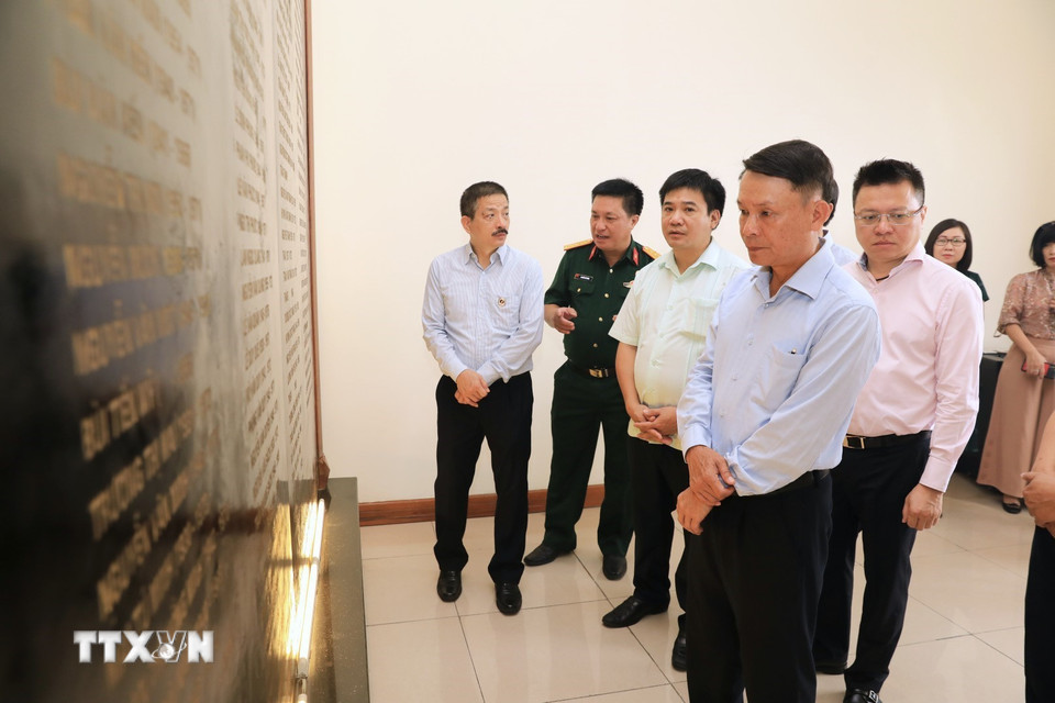 Ông Nguyễn Đức Lợi, Ủy viên Trung ương Đảng, Tổng Giám đốc Thông tấn xã Việt Nam cùng các đại biểu thăm bia ghi danh các liệt sỹ của TTXVN. (Ảnh: Thành Đạt/TTXVN)