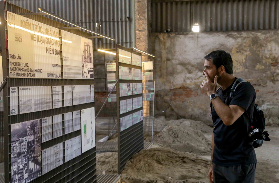 Du khách nước ngoài tham quan triển lãm 'Kiến trúc, Nhà máy và vẽ (lại) Giấc mơ hiện đại' tại nhà kho 10B. (Ảnh: Tuấn Đức/TTXVN)