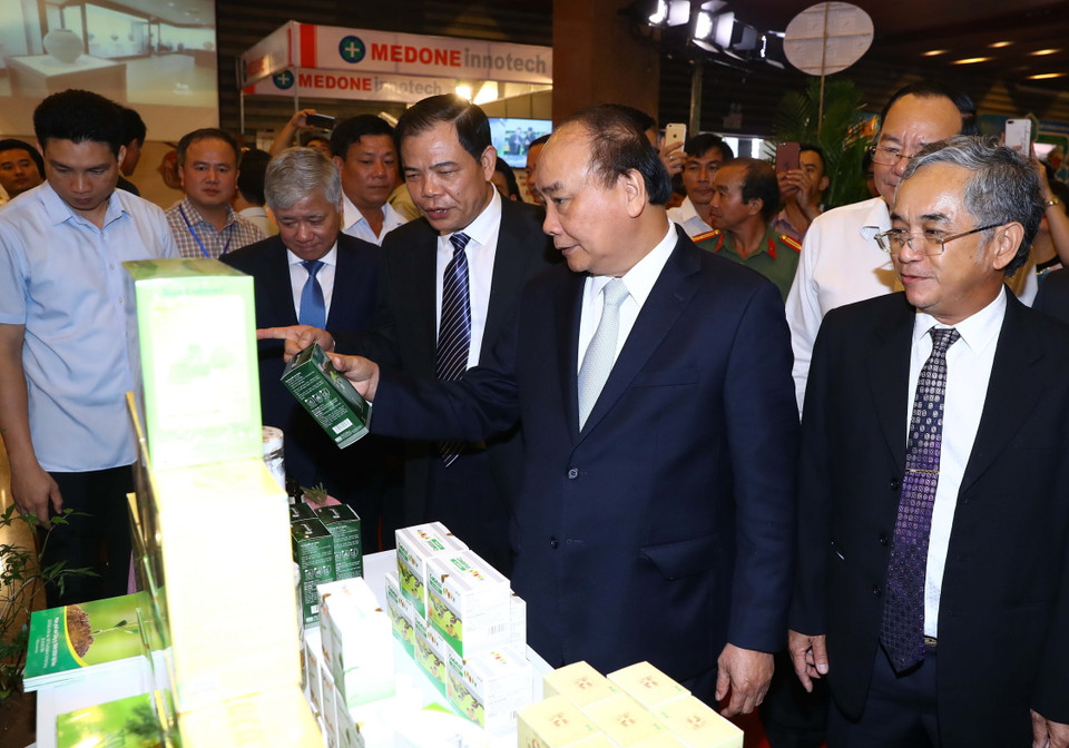 Thủ tướng Nguyễn Xuân Phúc và các đại biểu tham quan các gian hàng trưng bày sản phẩm tại triển lãm. (Ảnh: Thống Nhất/TTXVN)