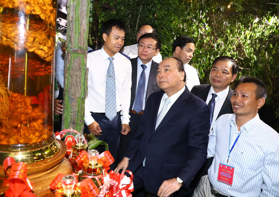 Thủ tướng Nguyễn Xuân Phúc và các đại biểu tham quan các gian hàng trưng bày sản phẩm tại triển lãm. (Ảnh: Thống Nhất/TTXVN)