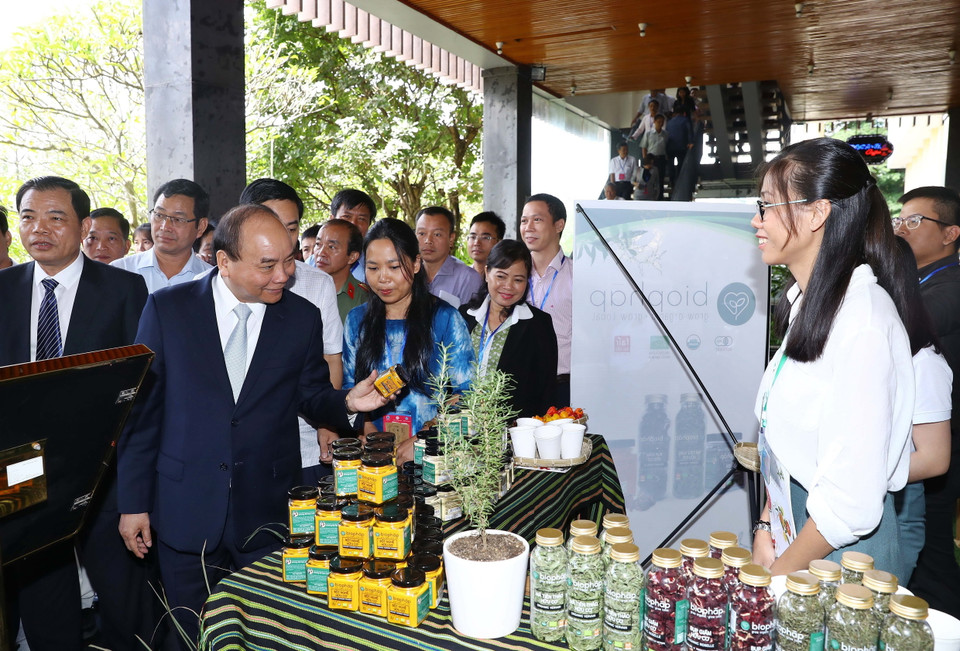 Thủ tướng Nguyễn Xuân Phúc và các đại biểu tham quan các gian hàng trưng bày sản phẩm tại triển lãm. (Ảnh: Thống Nhất/TTXVN)