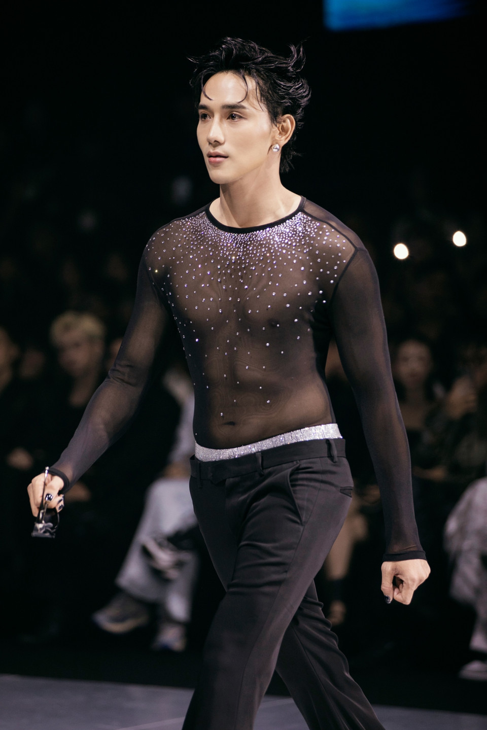 Phần trình diễn càng thêm đặc sắc khi có sự góp mặt của diễn viên, người mẫu Thuận Nguyễn, nam diễn viên diện mẫu áo làm từ chất liệu voan xuyên thấu được đính đá tỉ mỉ ở phần cổ “khéo léo” khoe trọn thân hình hoàn hảo sải bước đầy kiêu hãnh trên sàn catwalk. (Ảnh: CTV/Vietnam+)