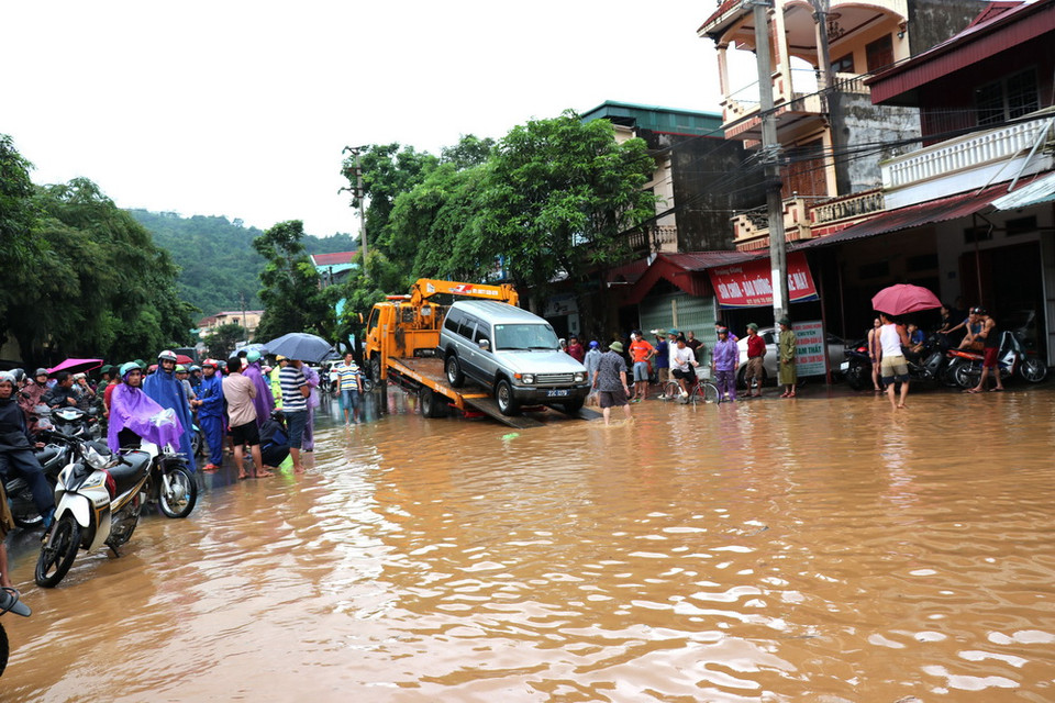 Khẩn trương cứu hộ xe ôtô ở thành phố Hà Giang bị tắc khi đi qua đoạn ngập úng. (Ảnh: Minh Tâm/Vietnam+)