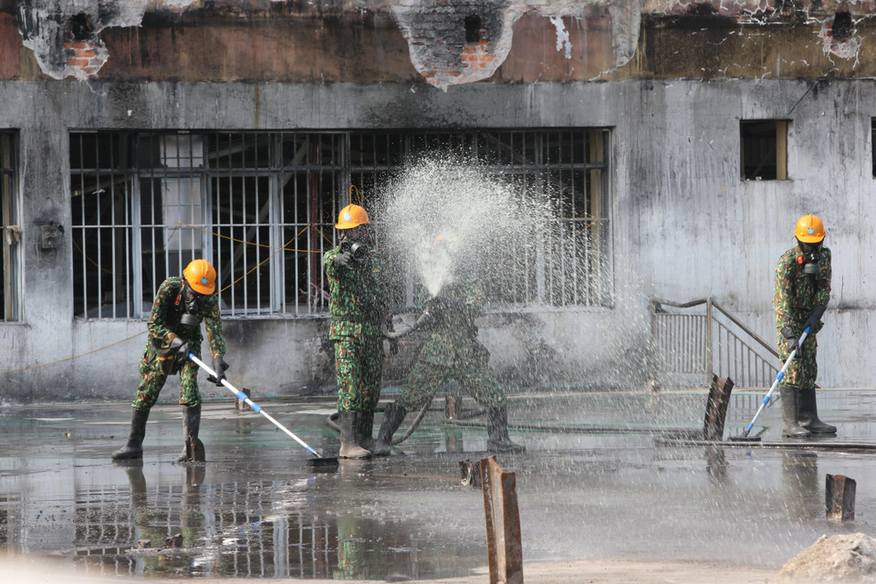 Lực lượng Binh chủng Hóa học phun hóa chất tẩy độc mặt nền nhà xưởng của Công ty Rạng Đông, ngày 5/10. (Ảnh: Dương Giang/TTXVN)