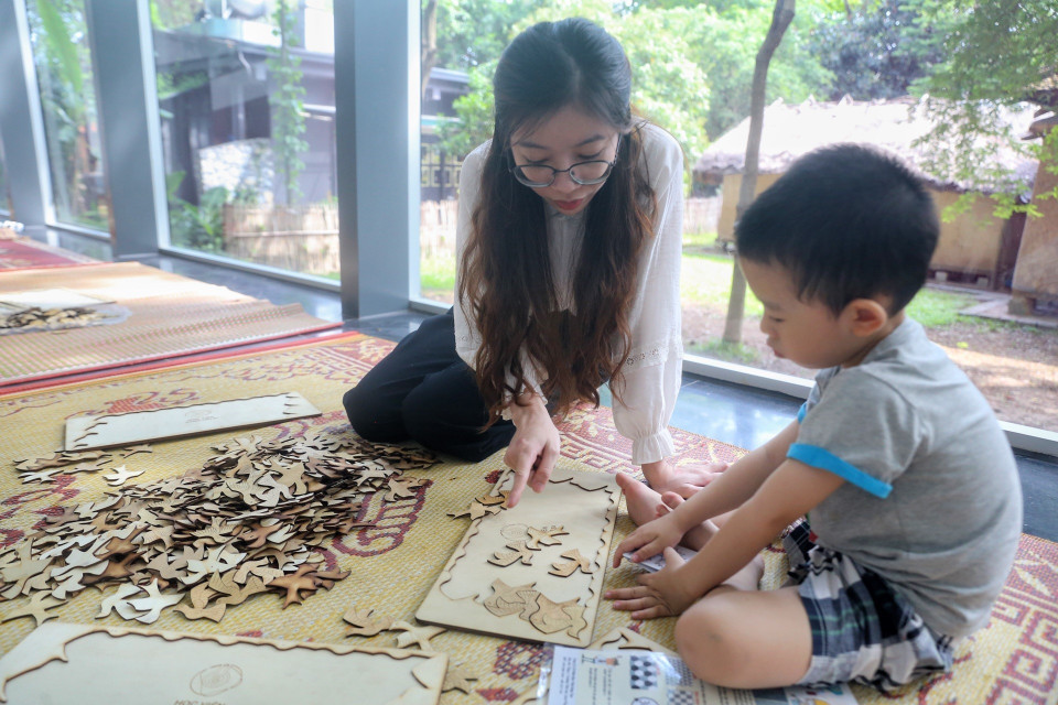 Em nhỏ cùng phụ huynh trải nghiệm chơi xếp hình. (Ảnh: Tuấn Đức/TTXVN)