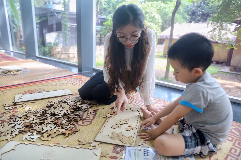 Em nhỏ cùng phụ huynh trải nghiệm chơi xếp hình. (Ảnh: Tuấn Đức/TTXVN)