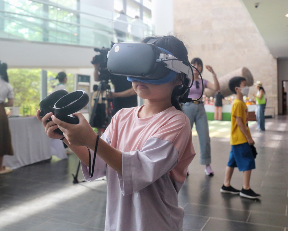 Em nhỏ trải nghiệm công nghệ thực tế ảo. (Ảnh: Tuấn Đức/TTXVN)