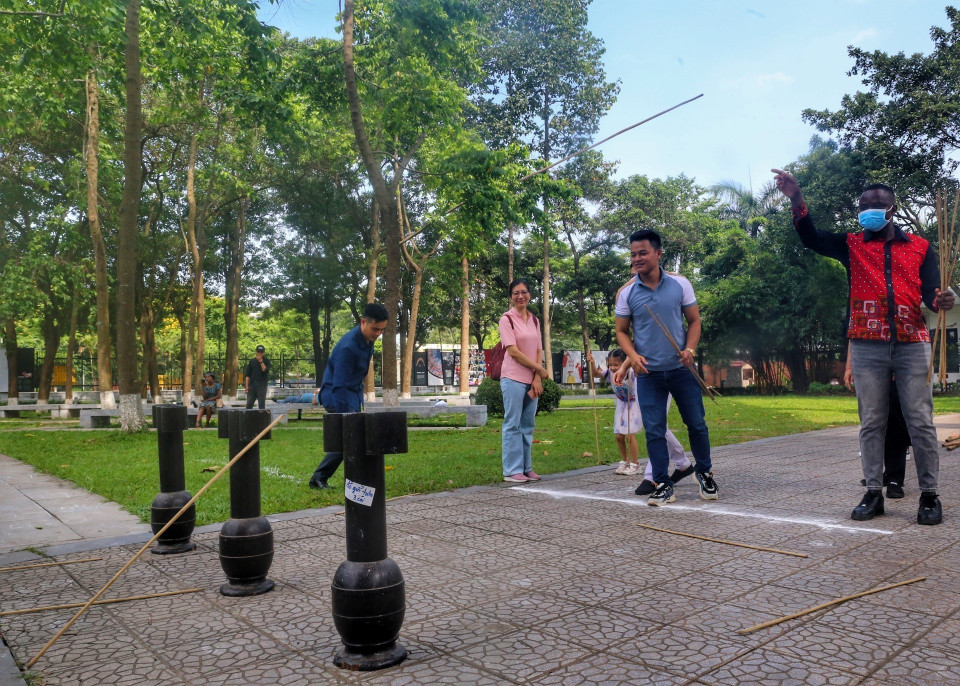 Du khách quốc tế trải nghiệm trò chơi Ném mũi tên. (Ảnh: Tuấn Đức/TTXVN)