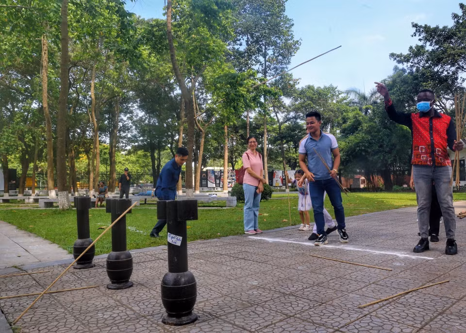 Du khách quốc tế trải nghiệm trò chơi Ném mũi tên. (Ảnh: Tuấn Đức/TTXVN)