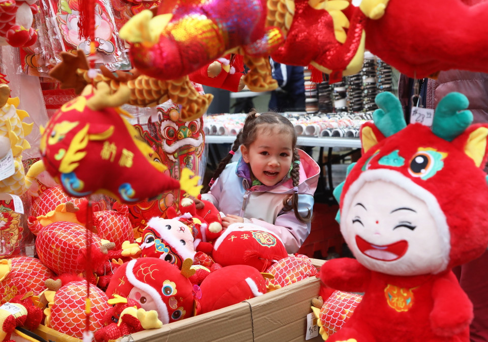Em nhỏ thích thú với những đồ chơi trang trí đón Tết Nguyên đán của người châu Á tại San Francisco, California, Mỹ. (Ảnh: THX/TTXVN)