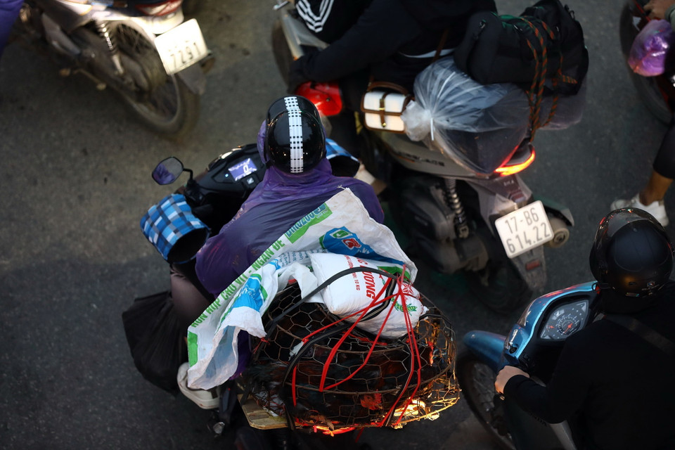 Người dân từ quê trở ra Hà Nội với các bọc đồ buộc sau xe. (Ảnh: Huy Hùng/TTXVN)