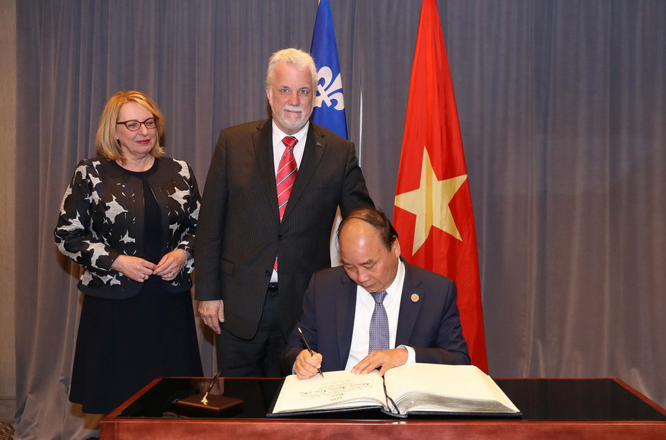 Thủ tướng Nguyễn Xuân Phúc gặp Thủ hiến bang Quebec Philippe Couillard. Trong ảnh: Thủ tướng Nguyễn Xuân Phúc ghi sổ lưu niệm. (Ảnh: Thống Nhất/TTXVN)