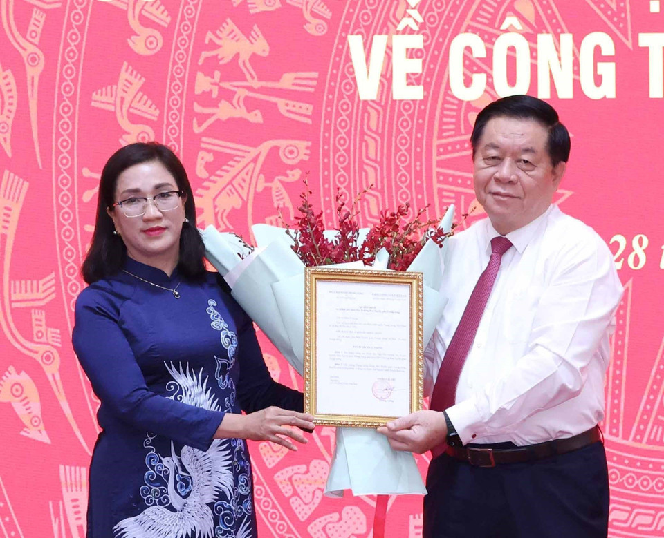 Trưởng Ban Tuyên giáo Trung ương Nguyễn Trọng Nghĩa trao quyết định cho bà Đinh Thị Mai. (Ảnh: Phương Hoa/TTXVN)
