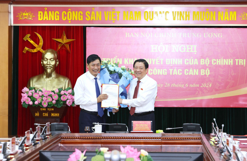 Ông Phan Đình Trạc, Ủy viên Bộ Chính trị, Bí thư Trung ương Đảng, Trưởng Ban Nội chính Trung ương trao Quyết định của Bộ Chính trị cho ông Nguyễn Hữu Đông. (Ảnh: Phương Hoa/TTXVN)