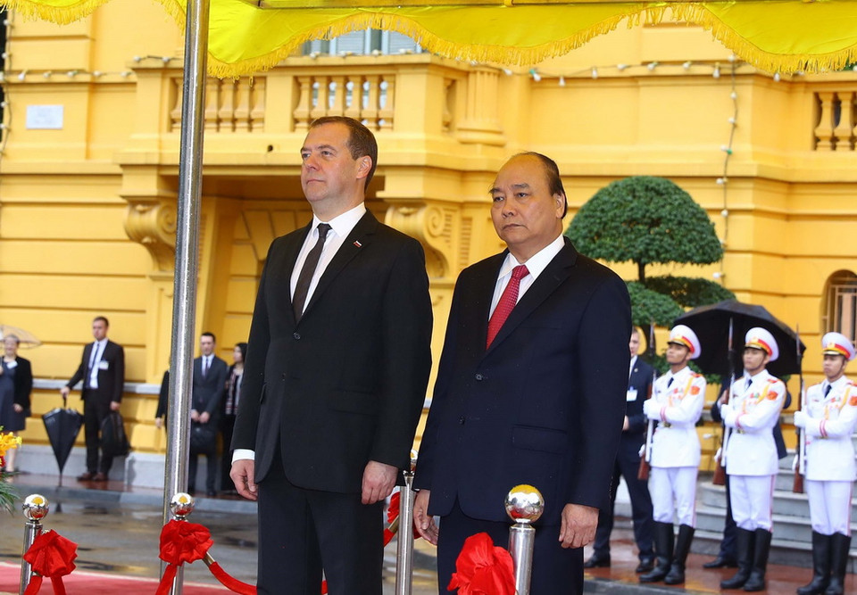 Thủ tướng Nguyễn Xuân Phúc và Thủ tướng Liên bang Nga Dmitry Medvedev trên bục danh dự, thực hiện nghi lễ chào cờ. (Ảnh: Thống Nhất/TTXVN)
