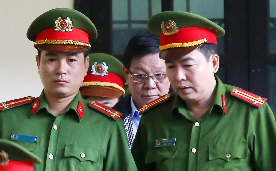 Lực lượng chức năng đưa bị cáo Phan Văn Vĩnh vào tòa. (Ảnh: Trung Kiên/TTXVN)