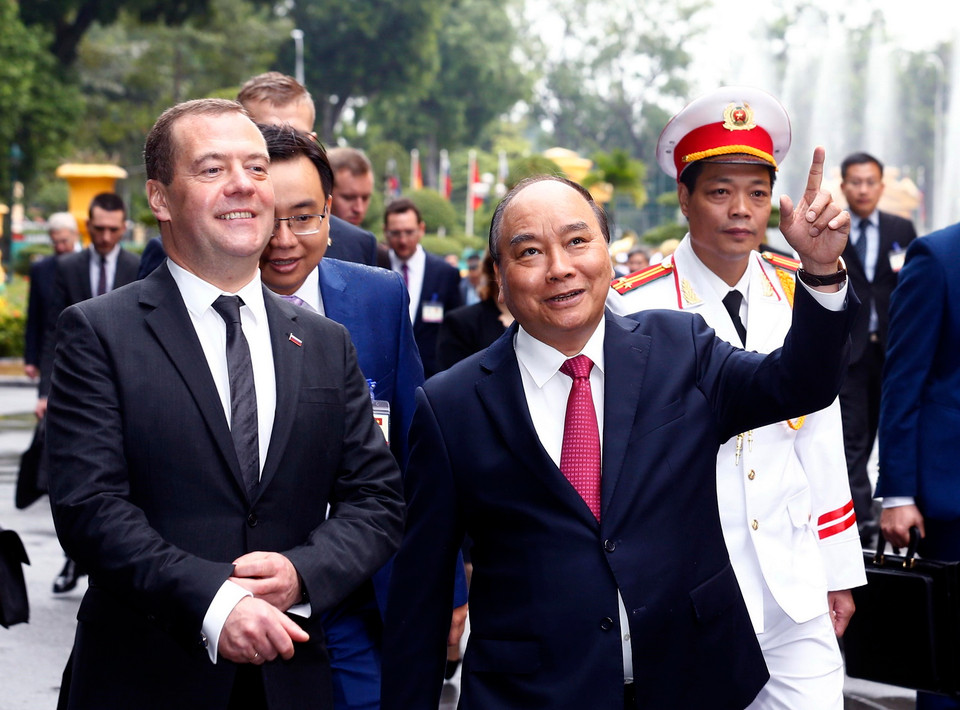 Thủ tướng Nguyễn Xuân Phúc giới thiệu với Thủ tướng LB Nga Dmitry Anatolyevich Medvedev về cảnh quan Khu di tích Phủ Chủ tịch trên đường tới Văn phòng Chính phủ. (Ảnh: Thống Nhất/TTXVN)