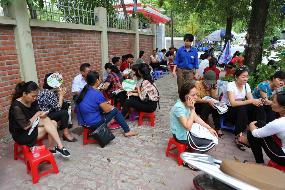 Phụ huynh các thí sinh chờ ngoài điểm Trường Trung học phổ thông Lương Thế Vinh, Hà Nội. (Ảnh: Thành Đạt/TTXVN)