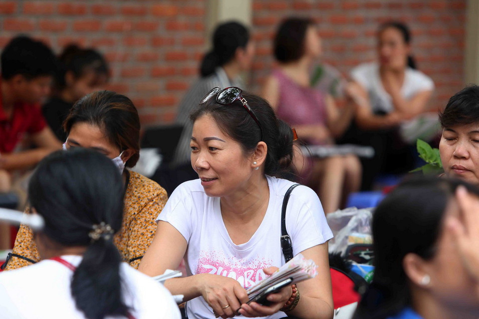 Phụ huynh các thí sinh chờ ngoài điểm Trường Trung học phổ thông Lương Thế Vinh, Hà Nội. (Ảnh: Thành Đạt/TTXVN)