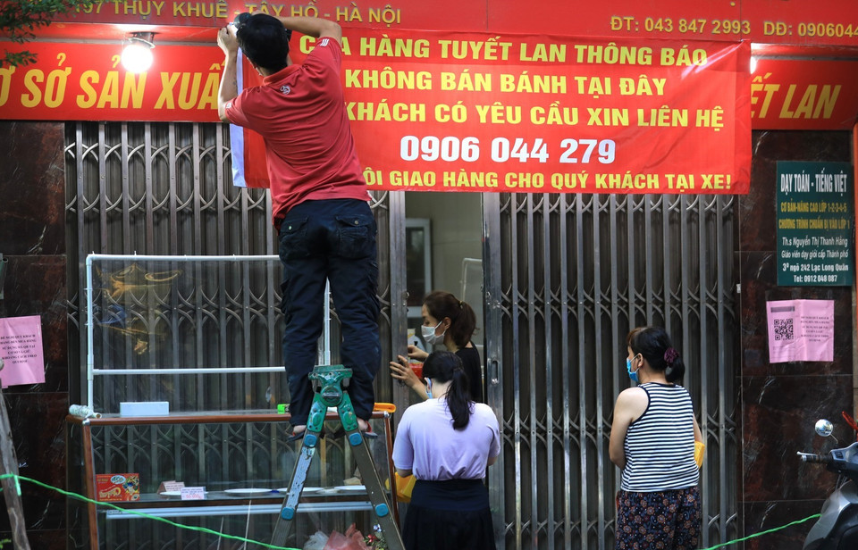 Dán thông báo 'Không bán tại đây' nhưng cửa hàng vẫn nửa đóng nửa mở bán bánh Trung thu cho khách hàng. (Ảnh: Thành Đạt/TTXVN)