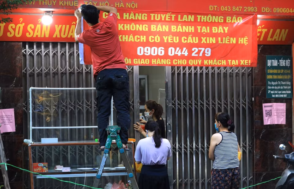 Dán thông báo 'Không bán tại đây' nhưng cửa hàng vẫn nửa đóng nửa mở bán bánh Trung thu cho khách hàng. (Ảnh: Thành Đạt/TTXVN)