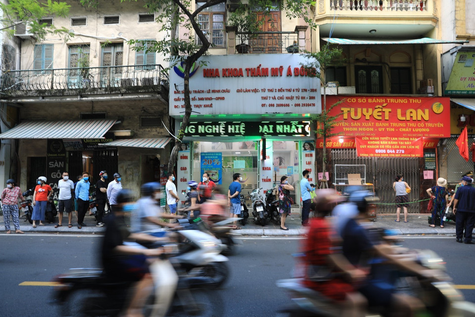 Vào 17h30 ngày 18/9, đúng giờ tan tầm, hàng chục người vẫn xếp hàng dài chờ mua bánh trên phố Thụy Khuê. (Ảnh: Thành Đạt/TTXVN)