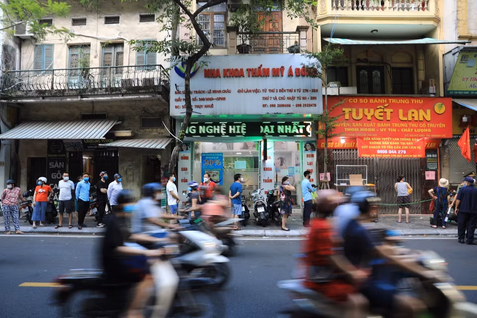 Vào 17h30 ngày 18/9, đúng giờ tan tầm, hàng chục người vẫn xếp hàng dài chờ mua bánh trên phố Thụy Khuê. (Ảnh: Thành Đạt/TTXVN)