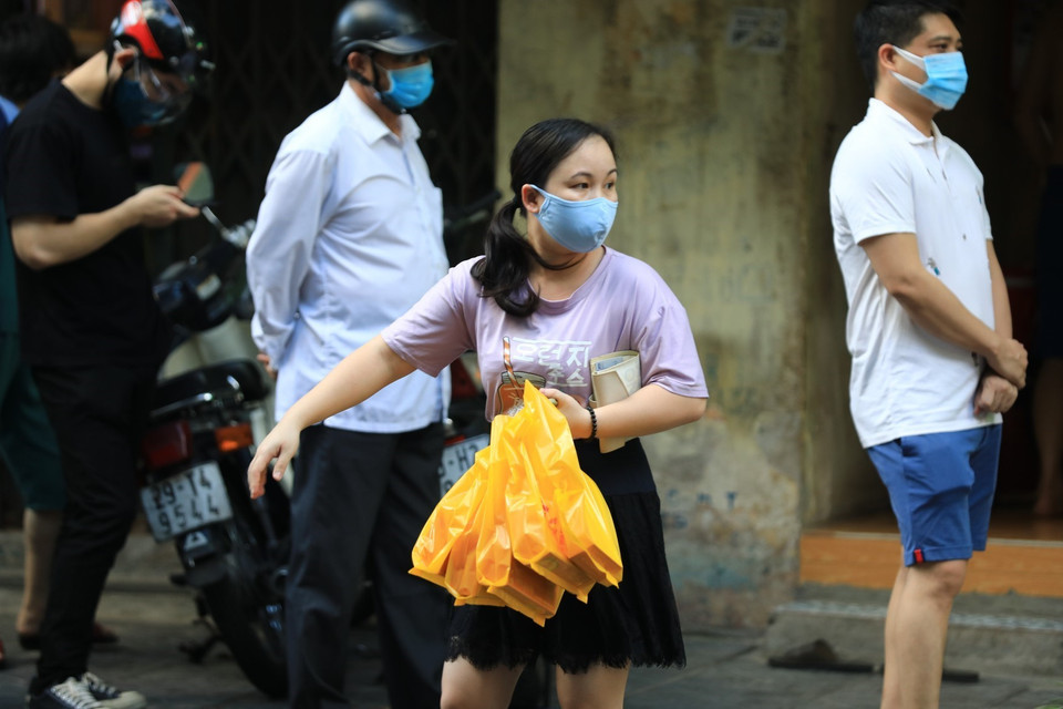 Một khách hàng đã mua được bánh Trung thu sau khi mất công xếp hàng. (Ảnh: Thành Đạt/TTXVN)