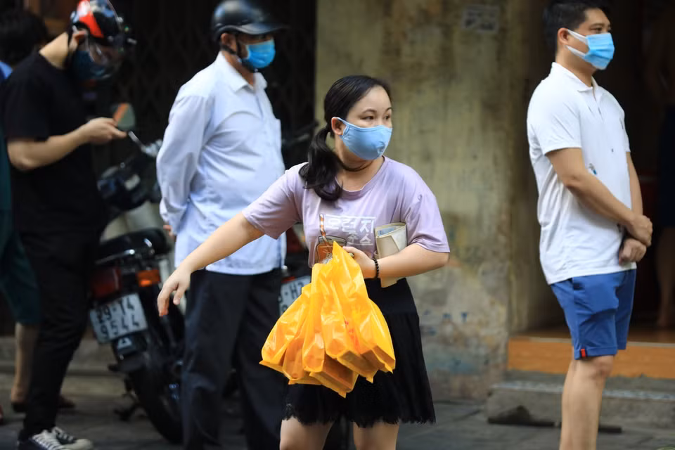 Một khách hàng đã mua được bánh Trung thu sau khi mất công xếp hàng. (Ảnh: Thành Đạt/TTXVN)