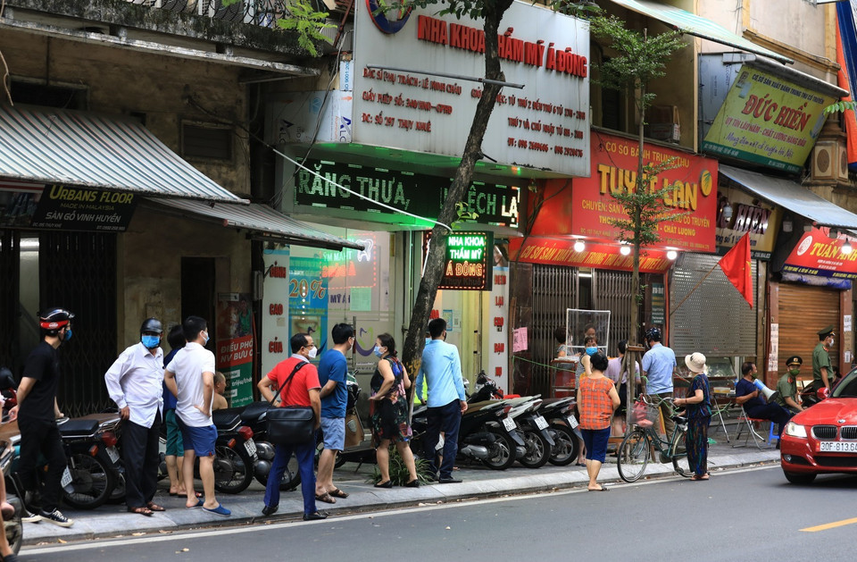 Vào 5 rưỡi chiều 18/9, đúng giờ tan tầm hàng chục người vẫn xếp hàng dài chờ mua bánh trên phố Thụy Khuê. (Ảnh: Thành Đạt/TTXVN)