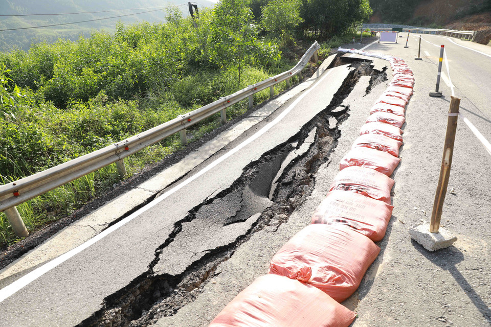 Một đoạn đường bị sụt lún trên Quốc lộ 12A do ảnh hưởng của đợt mưa lũ vừa qua. (Ảnh: Vũ Sinh/TTXVN)