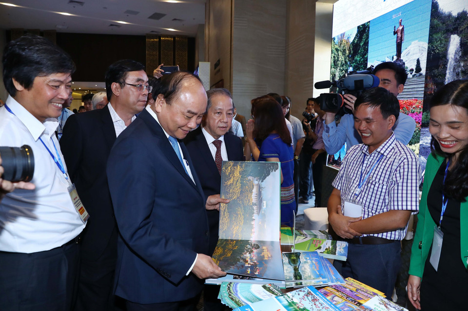 Thủ tướng Nguyễn Xuân Phúc và các đại biểu thăm các gian hàng trưng bày tại hội nghị. (Ảnh: Thống Nhất/TTXVN)