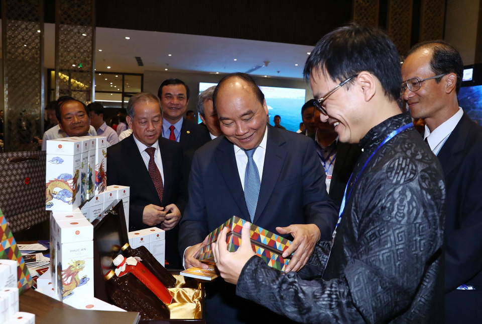 Thủ tướng Nguyễn Xuân Phúc và các đại biểu thăm các gian hàng trưng bày tại hội nghị. (Ảnh: Thống Nhất/TTXVN)