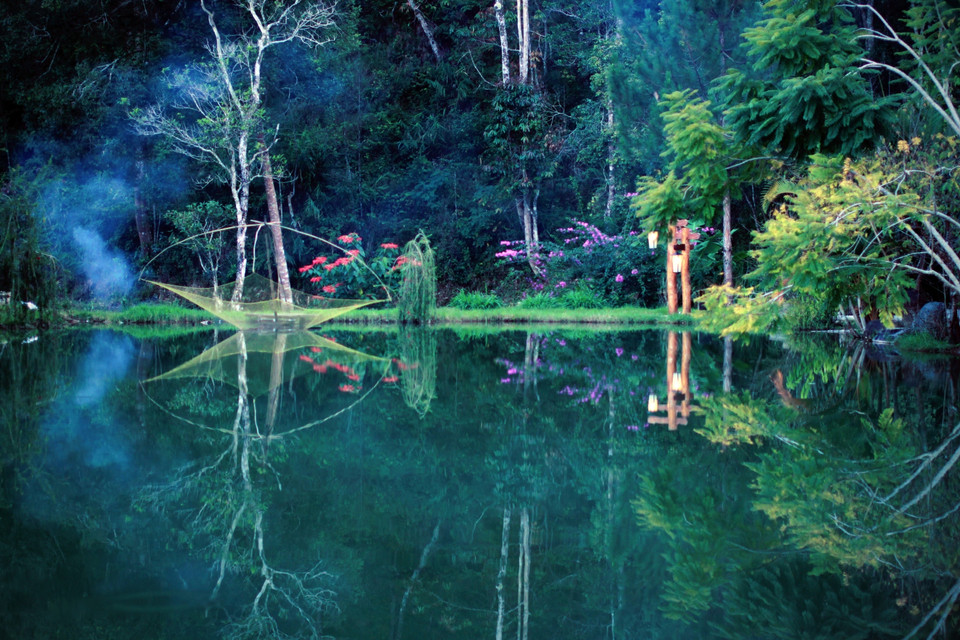 Sau những vạt nắng chiều bừng lên lần cuối quét qua những ngọn thông già, mặt hồ nước trở nên tĩnh lặng lạ thường. (Ảnh: Xuân Mai/Vietnam+)