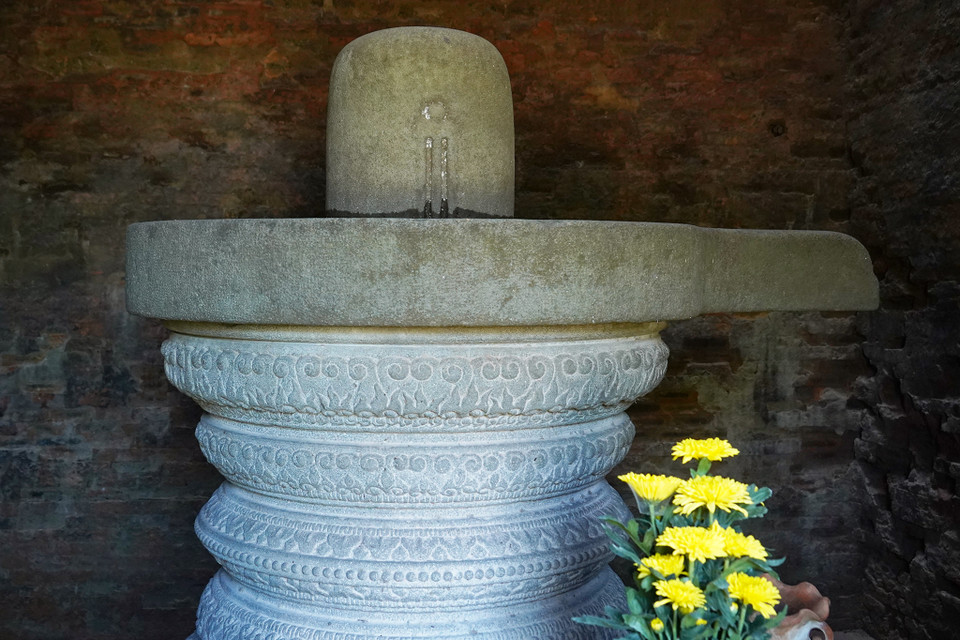 Bước vào bên trong tháp có thờ bộ ngẫu tượng Linga và Yoni: Linga được đặt trên bệ Yoni tượng trưng cho sự hòa hợp âm dương, là nguồn gốc mọi sự sinh sôi nảy nở, thể hiện tín ngưỡng phồn thực phổ biến của người nông dân Chămpa. (Ảnh: Việt Anh/Vietnam+)