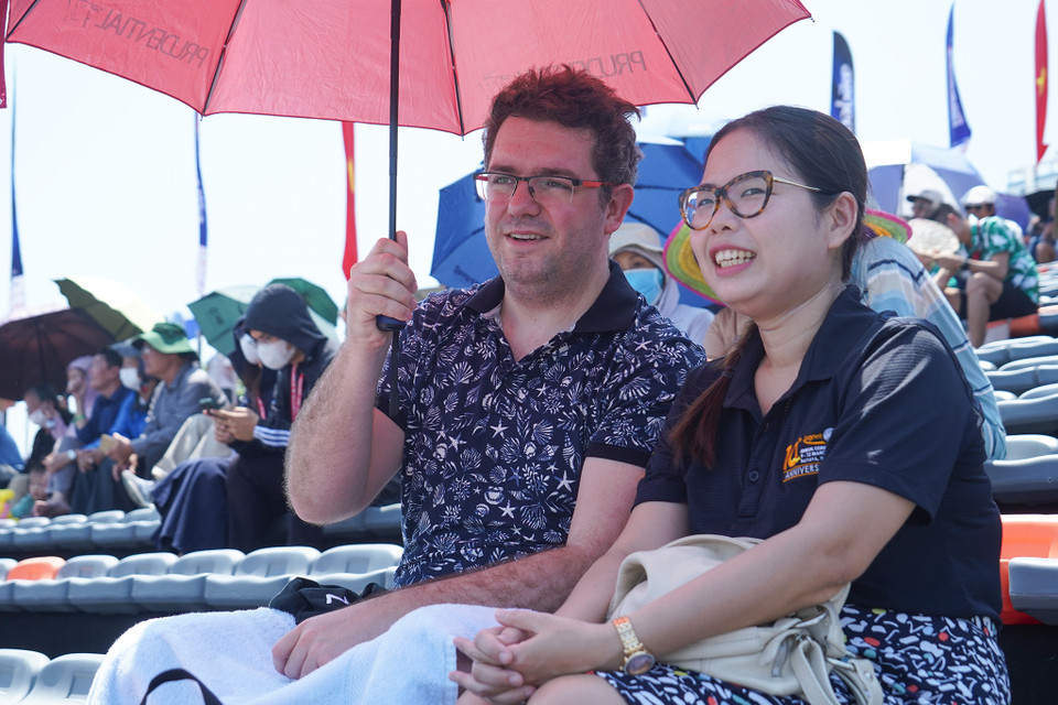 Anh Nicolas Lasserre (Pháp) và vợ sắp cưới là chị Nguyễn Nhật Minh đặt vé về Việt Nam để theo dõi Giải đấu. Anh cho biết bản thân không giỏi chịu nóng nên đã phải mang thêm ô che nắng và khăn ướt để tránh bị 'sốc nhiệt'. (Ảnh: Việt Anh/Vietnam+)