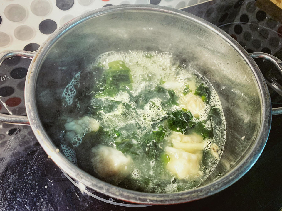 Đun nước xương, nêm các loại gia vị xong nước sôi cho sủi cảo vào đến khi sủi cảo nổi là chín thì thả rong biển, lá hẹ vào khoảng 15 giây thì tắt bếp. (Ảnh: Mai Mai/Vietnam+)