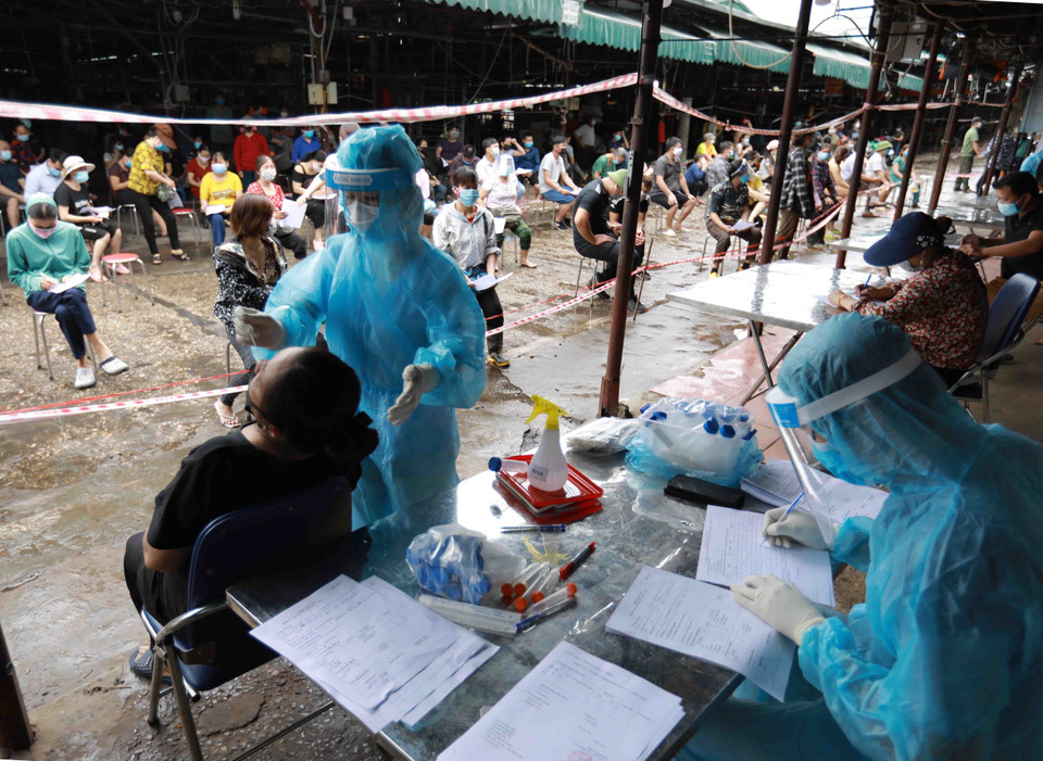  Lấy mẫu xét nghiệm cho các tiểu thương tại chợ Phùng Khoang.(Ảnh: Vũ Sinh/TTXVN)