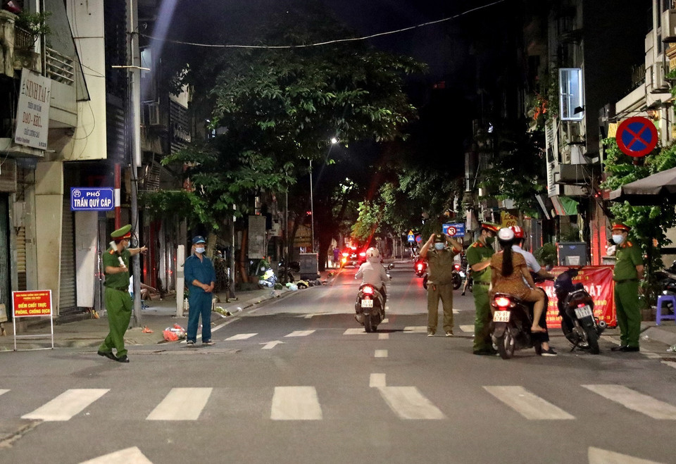 Các chốt kiểm soát COVID-19 tại nhiều điểm trong thành phố tăng cường kiểm tra người tham gia giao thông vào buổi tối. (Ảnh: Ngọc Hà/TTXVN)