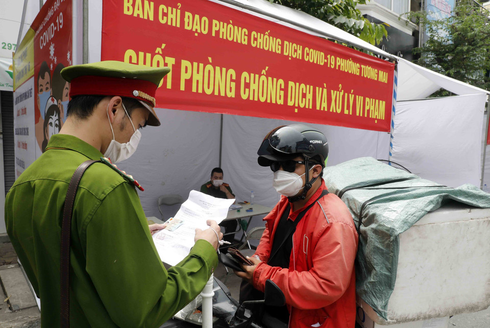 Công an Hà Nội đã lập chốt kiểm soát COVID-19 tại nhiều tuyến phố trung tâm Thủ đô để kiểm tra, xử phạt những trường hợp người dân ra ngoài không có nhu cầu thiết yếu, đi làm không có giấy tờ tùy thân, giấy xác nhận đi làm có đóng dấu của cơ quan, đơn vị... (Ảnh: Trần Việt/TTXVN)