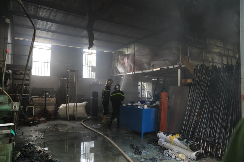 Lực lượng chức năng tiến vào bên trong kho hàng để chữa cháy. (Ảnh: Nhật Anh/TTXVN)